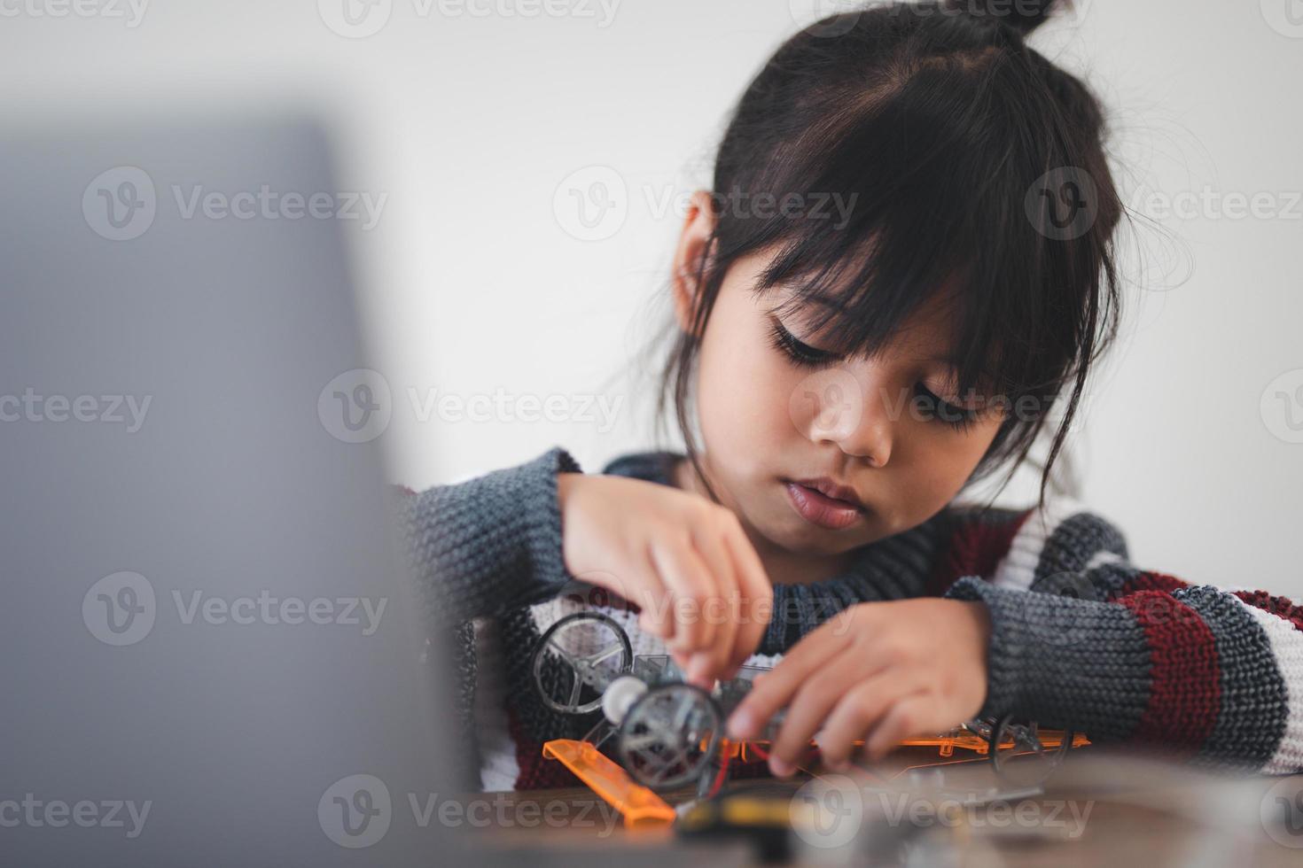 Inventive kid constructing robot cars at home photo