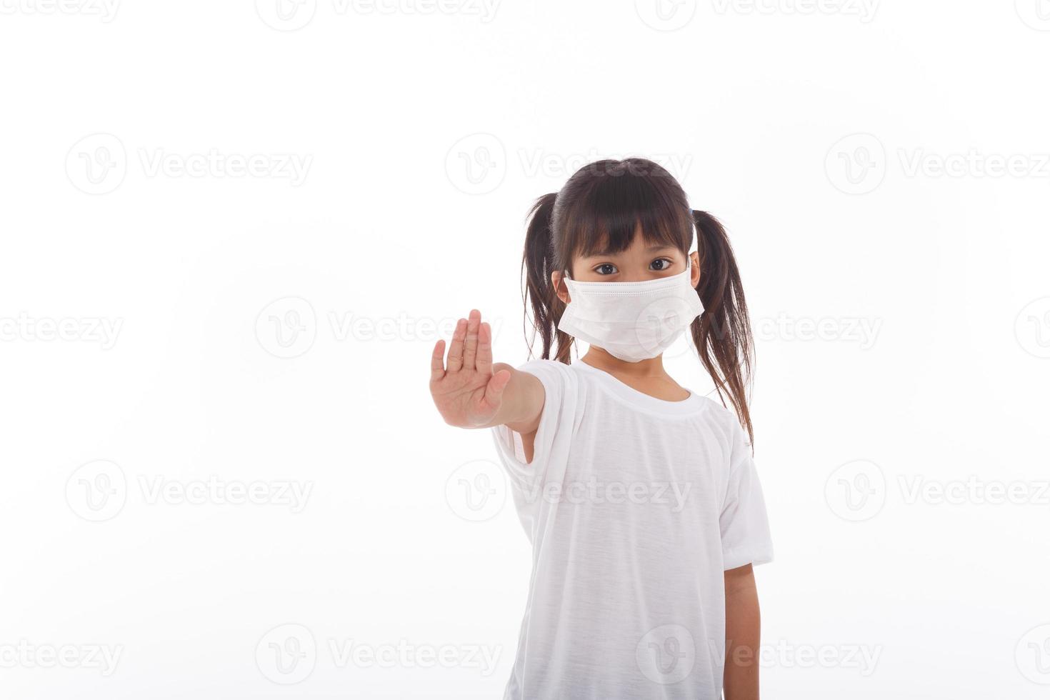coronavirus covid-19.quédese en casa manténgase a salvo concepto.niña con máscara para protegerse.muestre el gesto de detener las manos para detener el brote del virus de la corona.síntomas del virus pandémico del coronavirus. foto