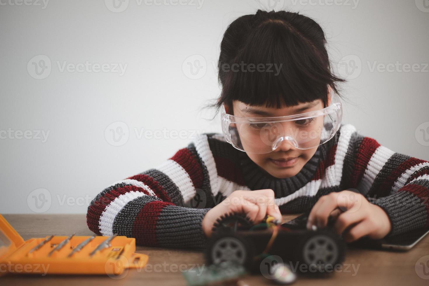 Inventive kid constructing robot cars at home photo