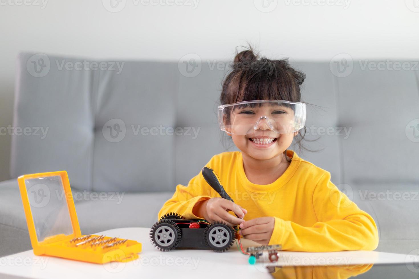 Inventive kid constructing robot cars at home photo