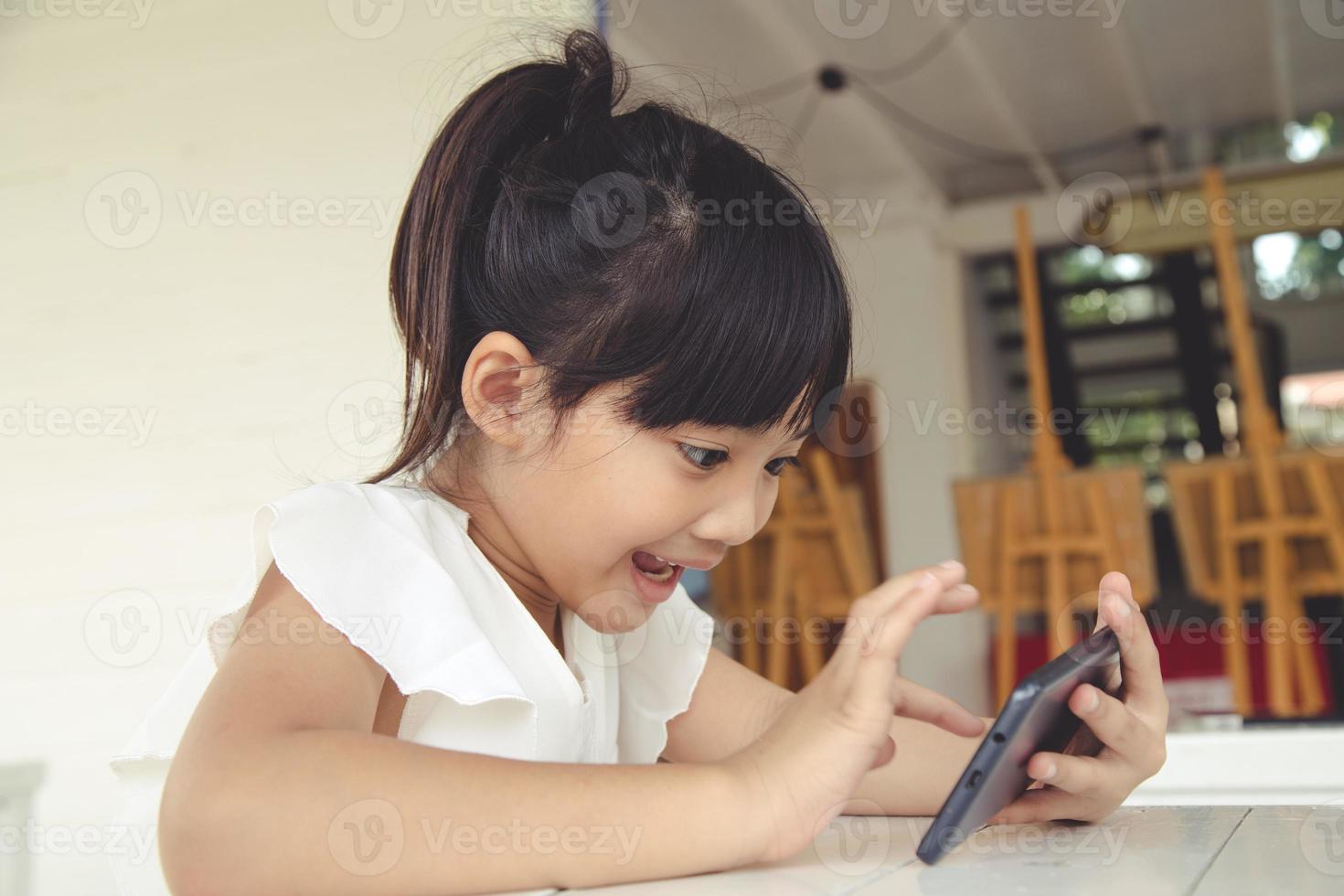 niña usando teléfono inteligente, concepto de redes sociales. foto