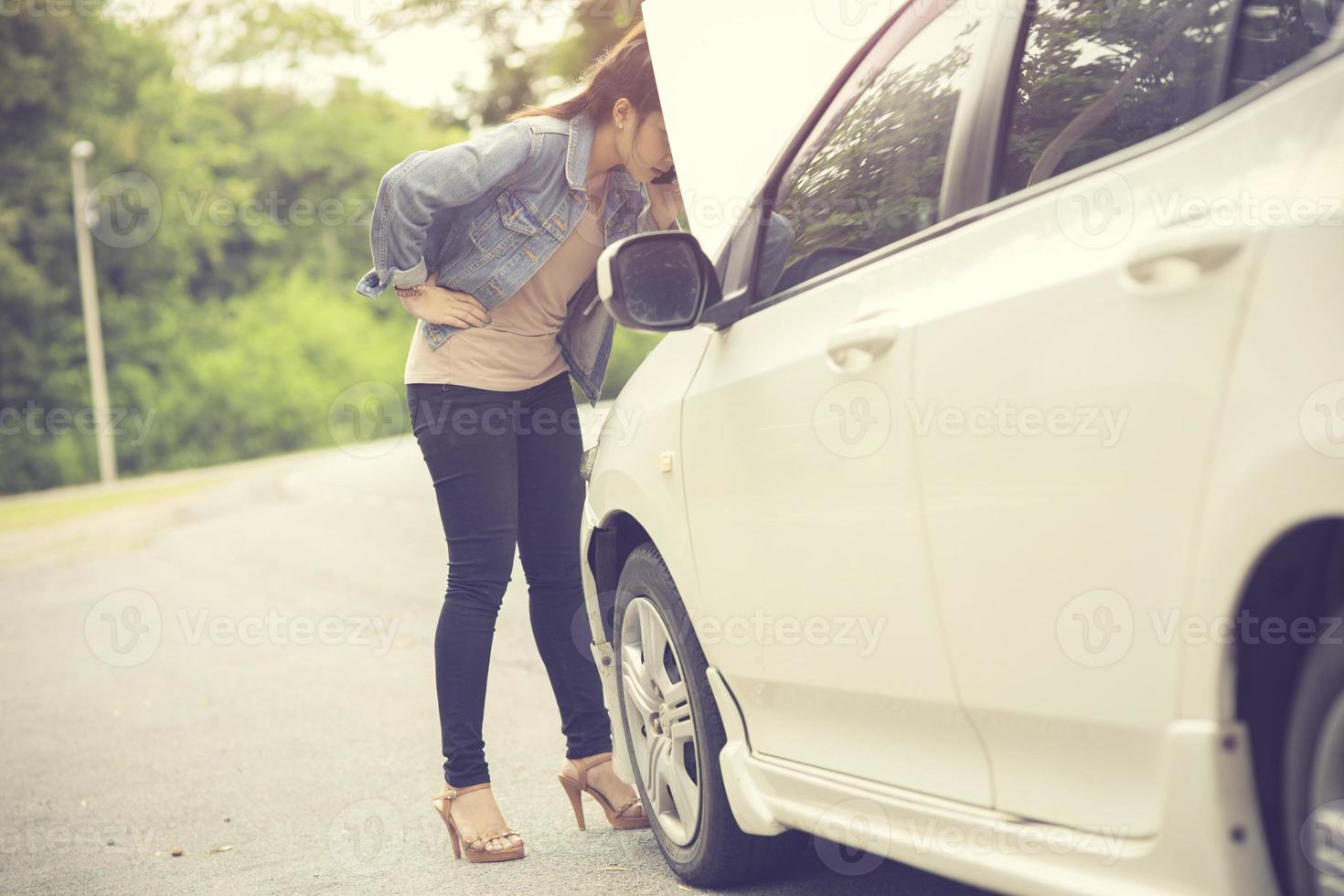 Women spection She opened the hood Broken car on the side See engines that are damaged or not.Vintage color photo