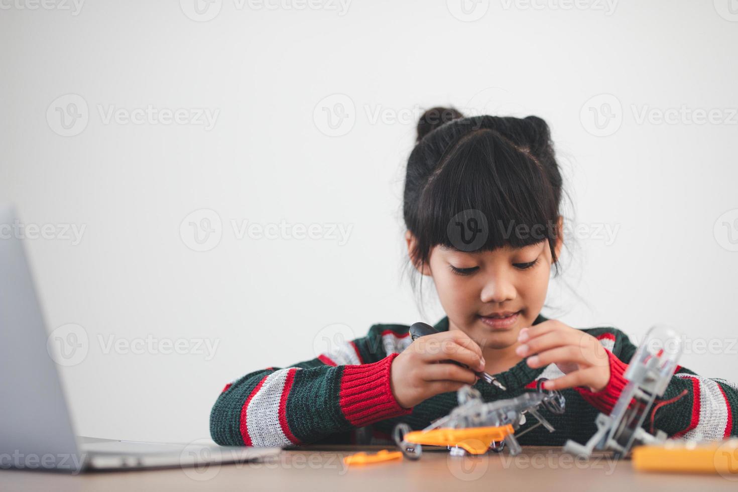 Inventive kid constructing robot cars at home photo