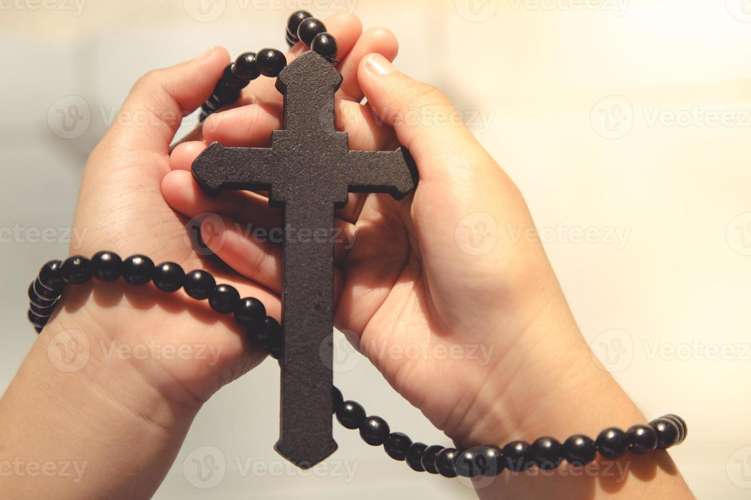 cruz de madera en manos rezando con fondo exterior. día internacional de oración concepto de pascua y viernes santo. foto