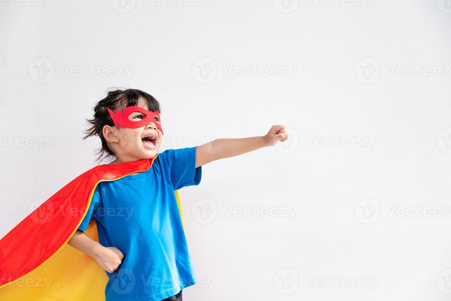 Niña divertida jugando superhéroe de poder sobre fondo blanco. concepto de superhéroe. foto