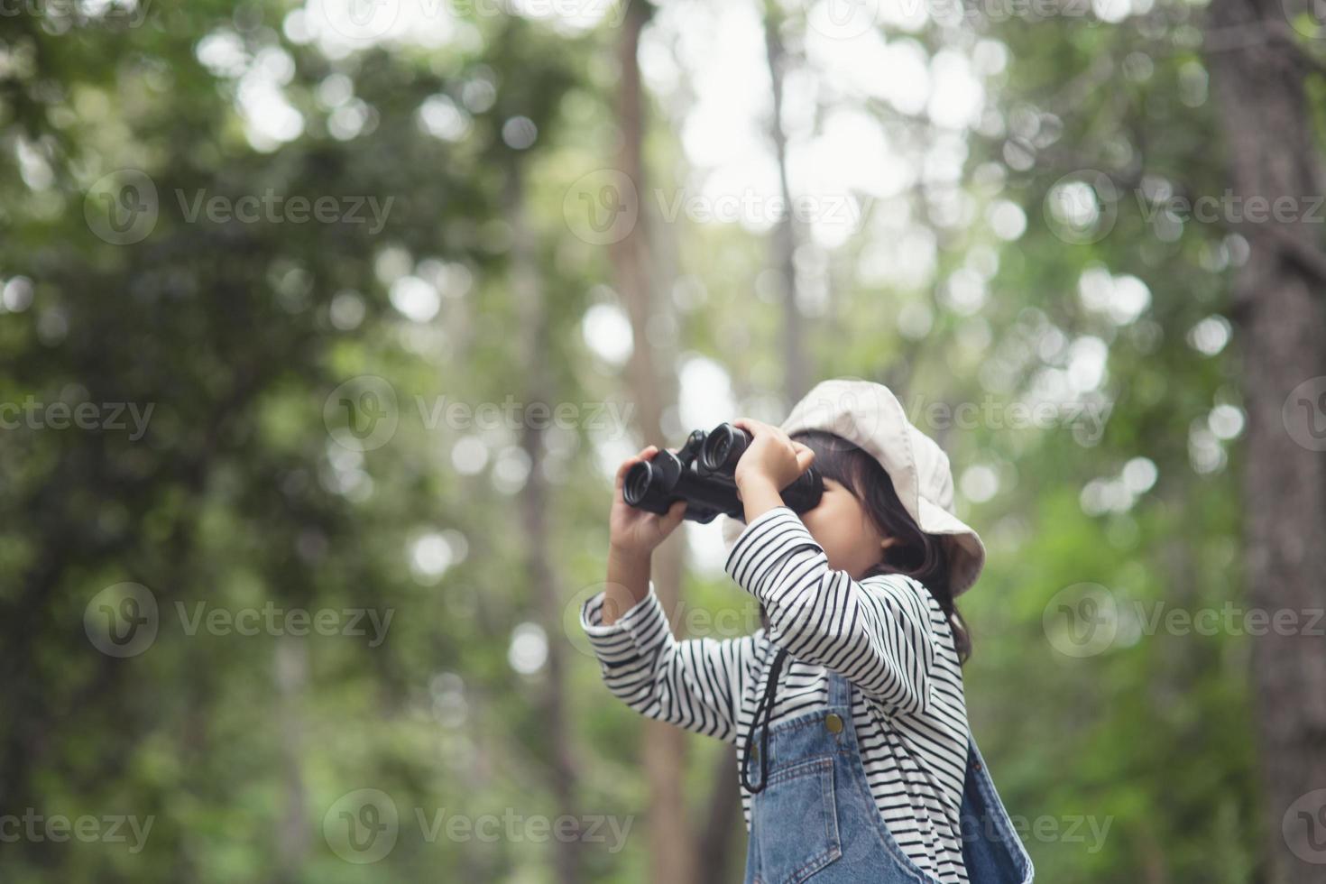 Happy kid looking ahead. Smiling child with the binoculars. Travel and adventure concept. Freedom, vacation photo