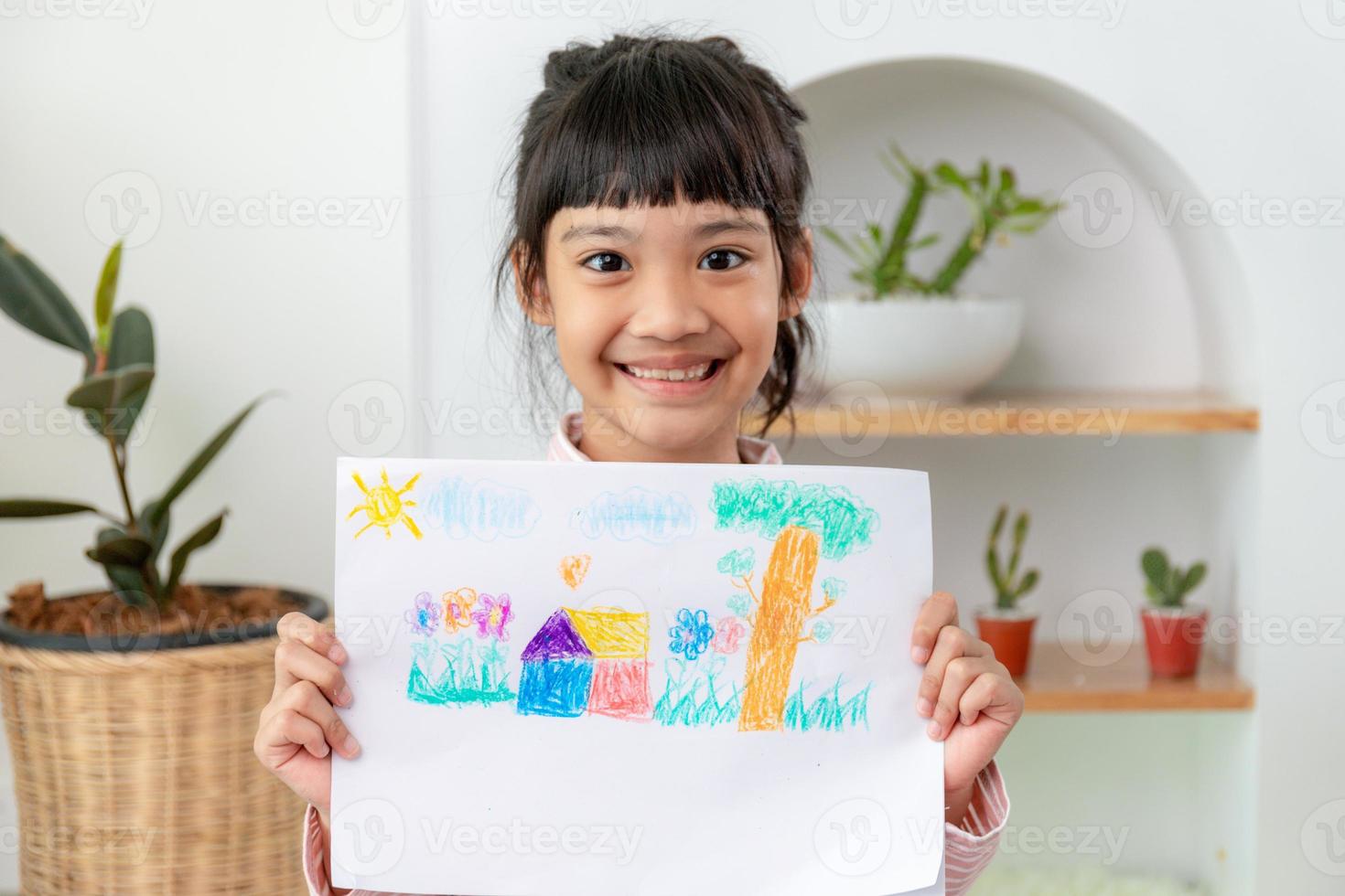 Little preschool girl displaying her picture proudly photo