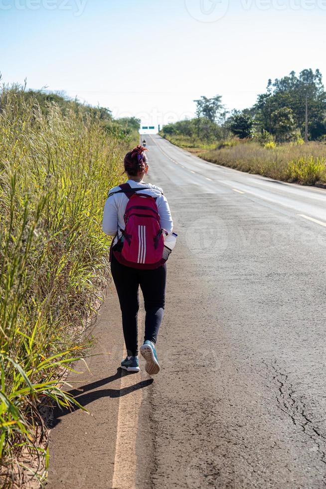 woman with backpack walking photo
