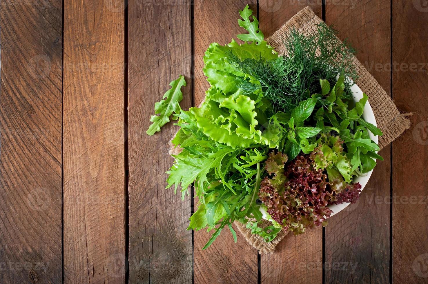 Variety fresh organic herbs  on wooden background in rustic style photo