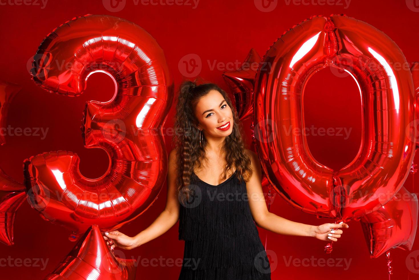 young adult woman on the background of red balloons photo
