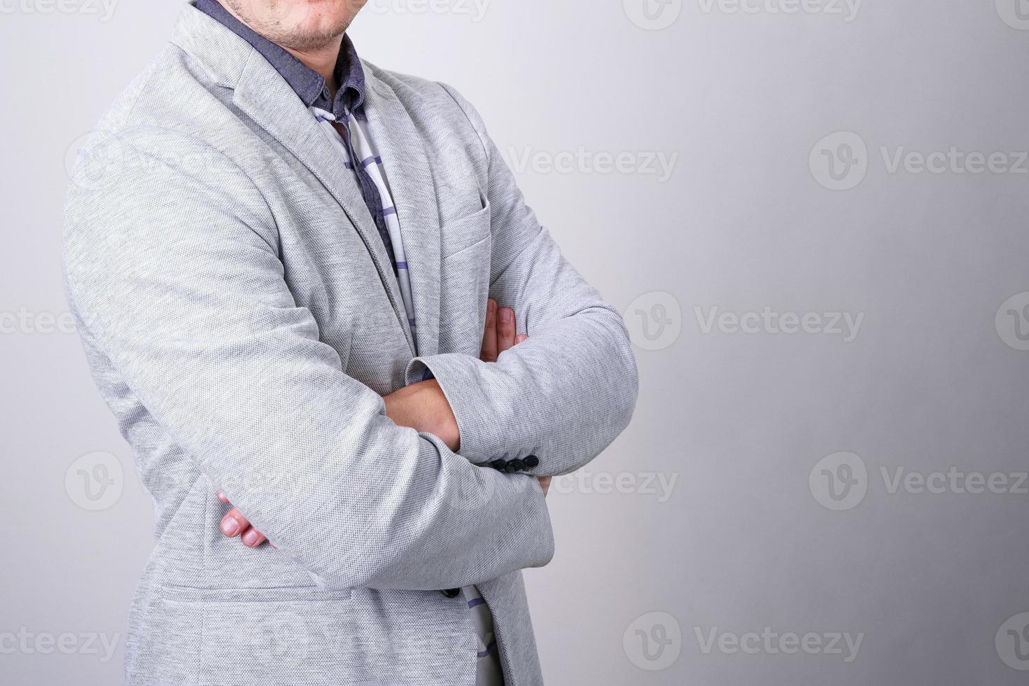 Business man on light background with folded hands on light background in jacket photo