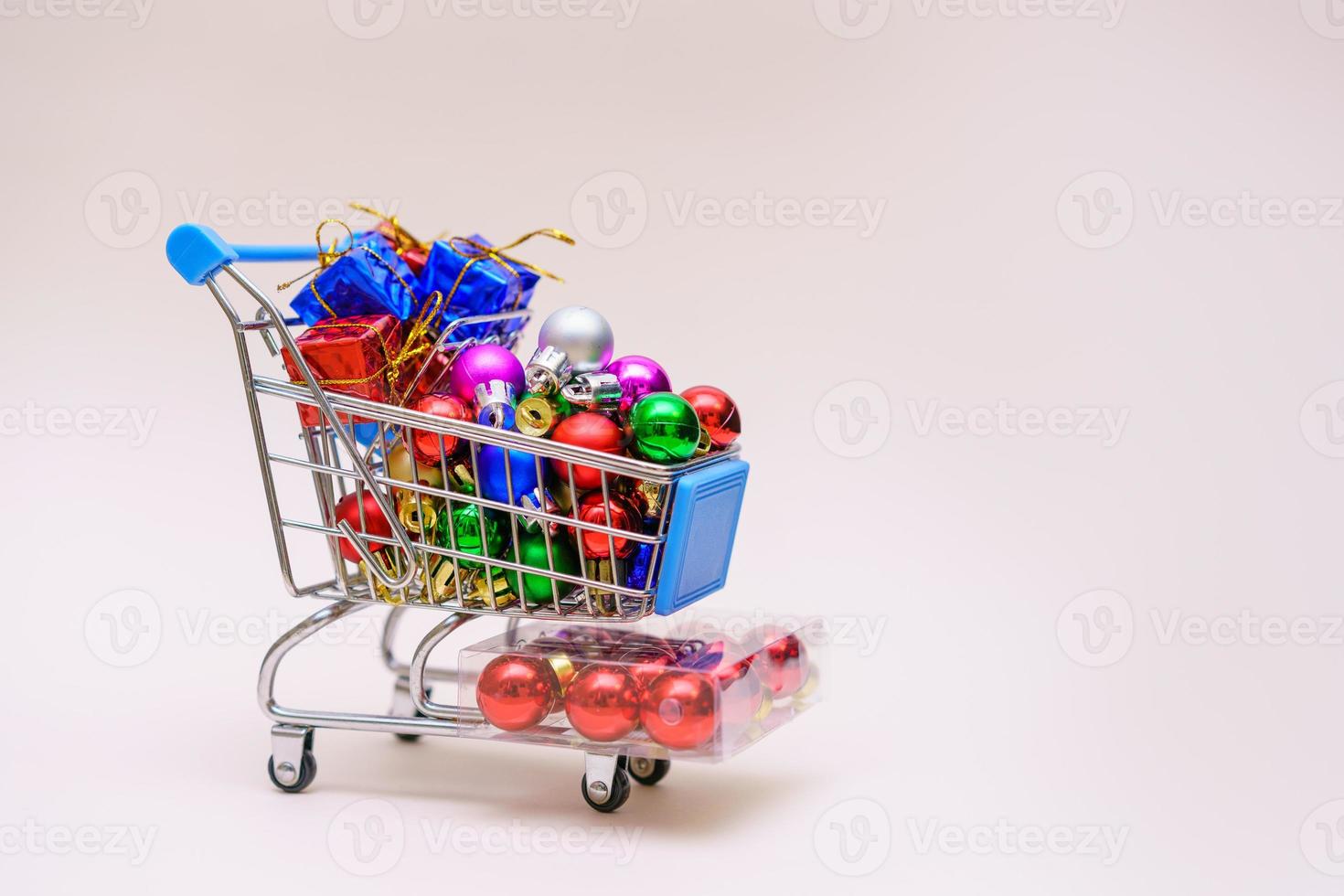 concepto para la temporada de compras navideñas carrito de minitienda lleno de cajas de regalo foto