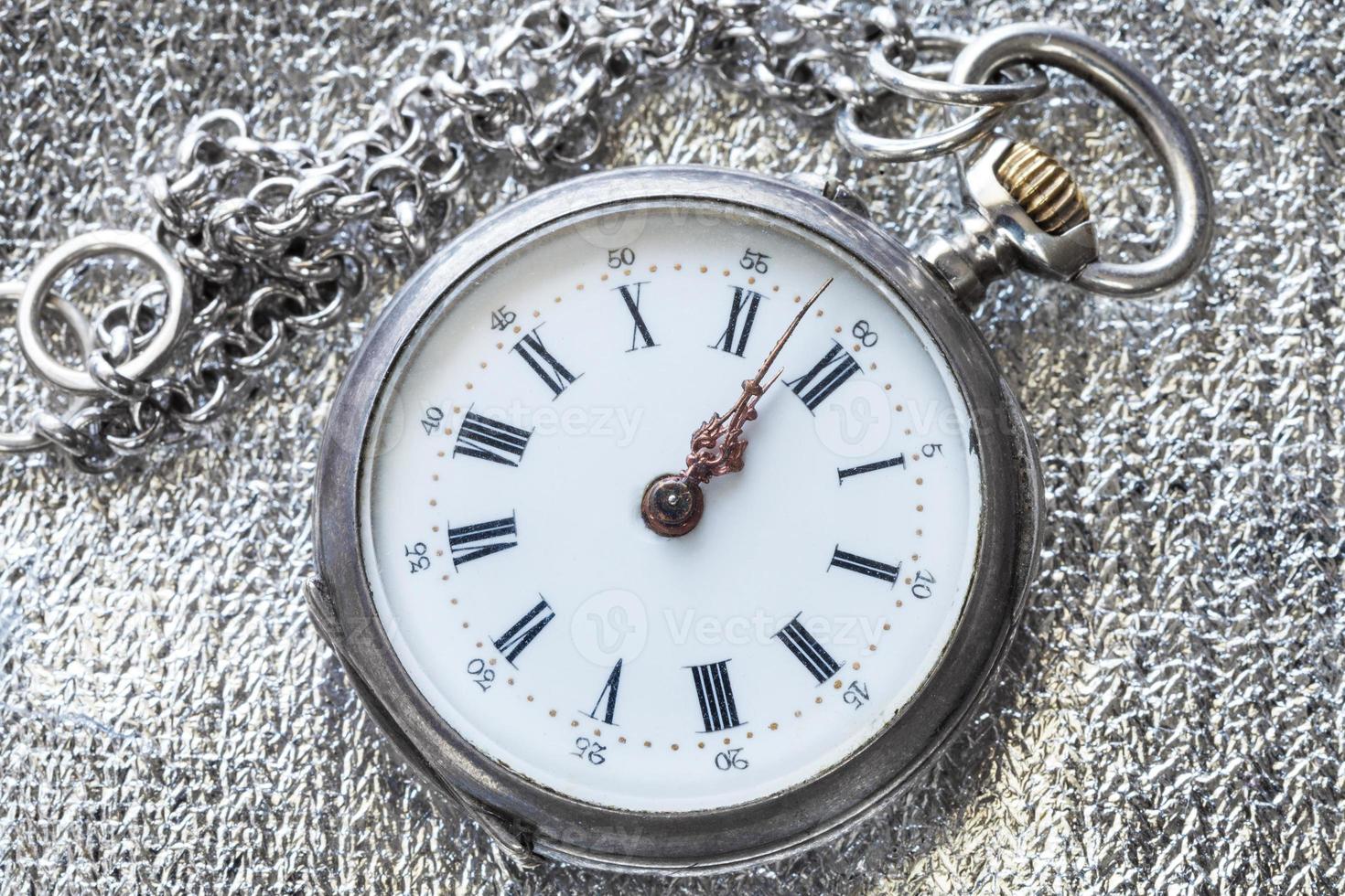 retro pocket watch on silver fabric close up photo