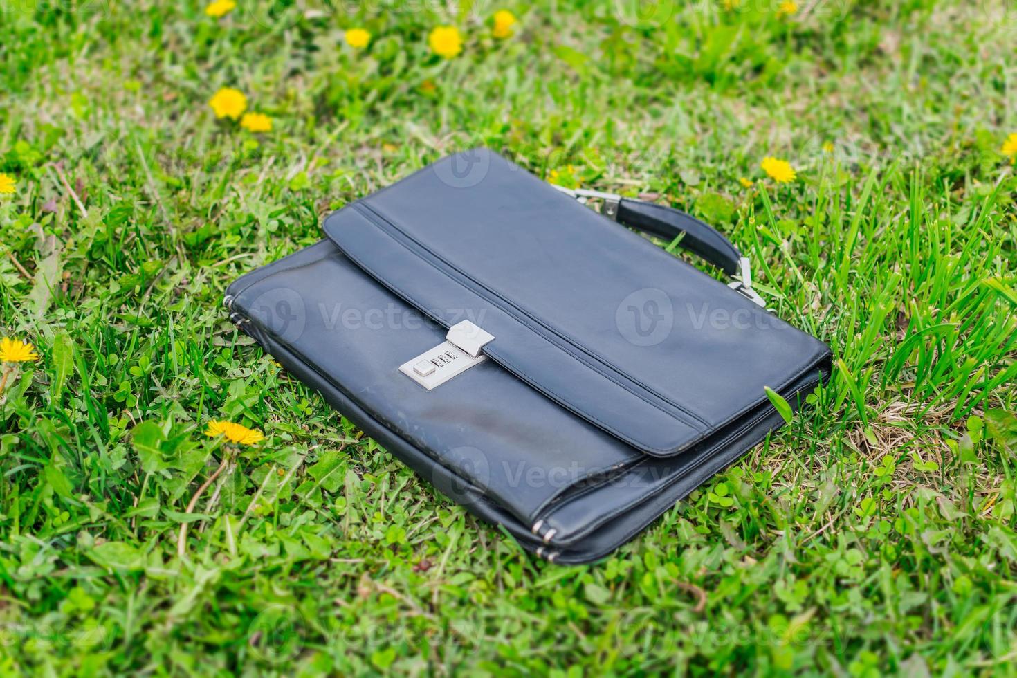Briefcase forgotten on the grass in the park with documents photo