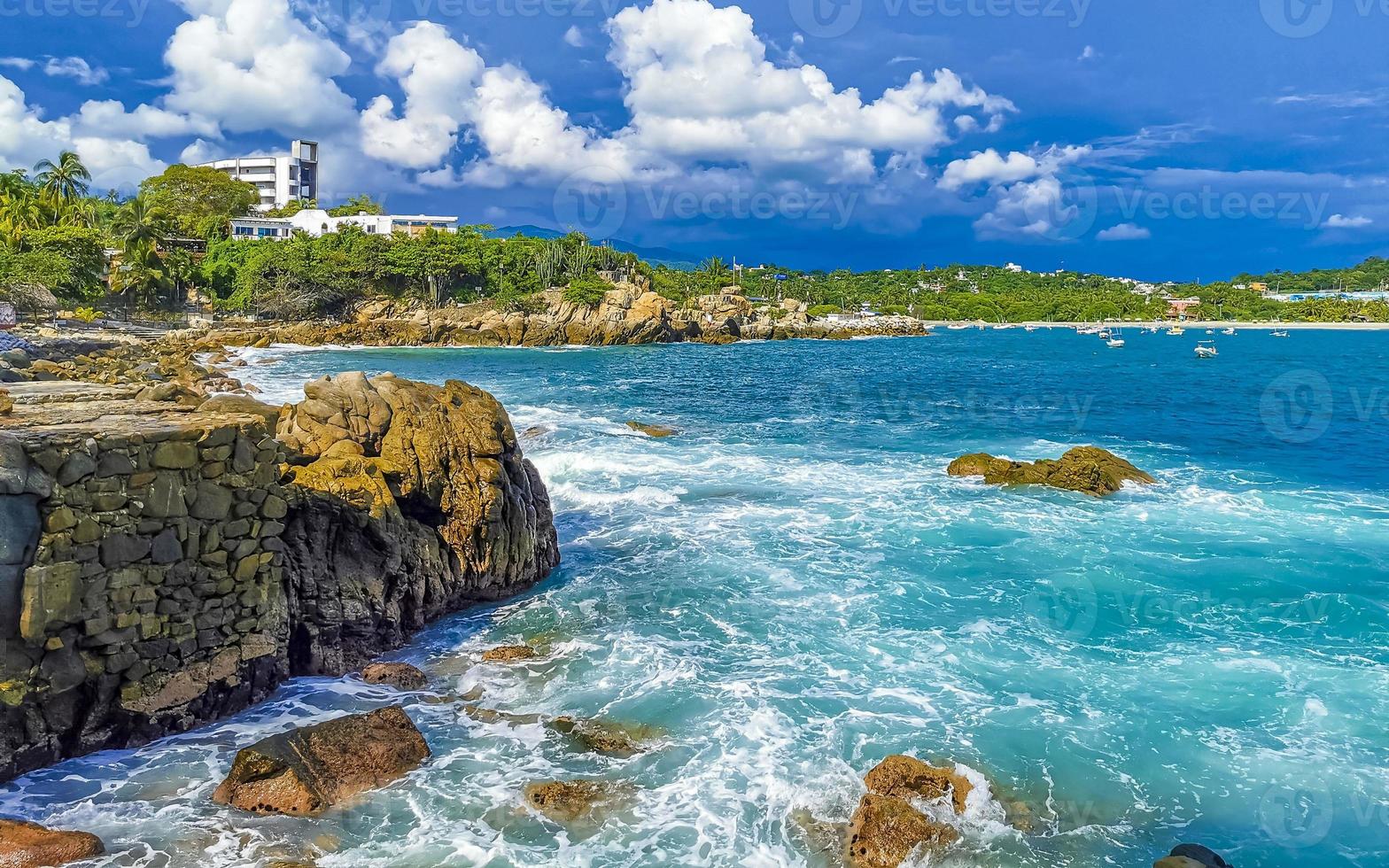 Beautiful surfer waves rocks cliffs at beach Puerto Escondido Mexico. photo