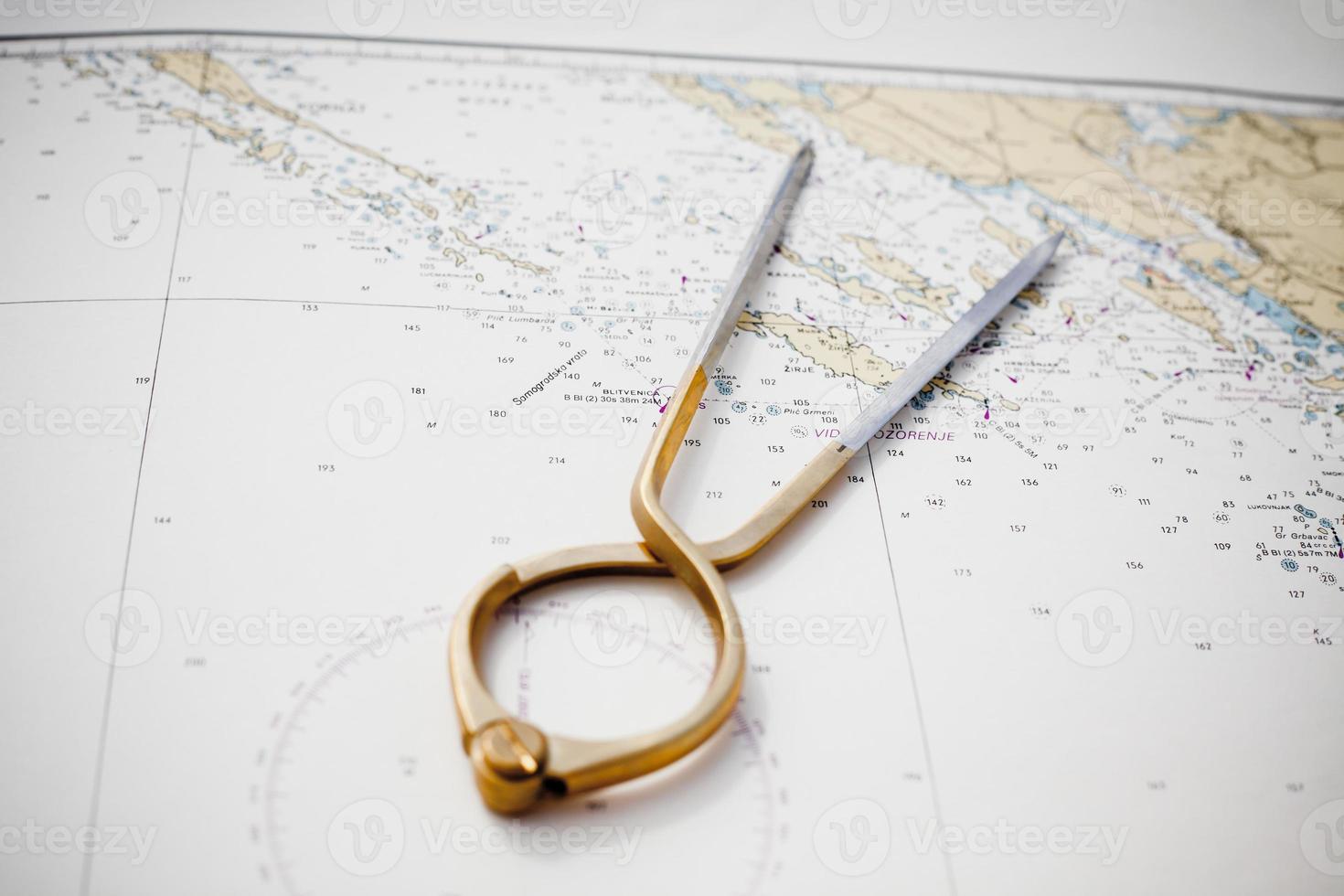 Pair of compasses for navigation on a sea map photo