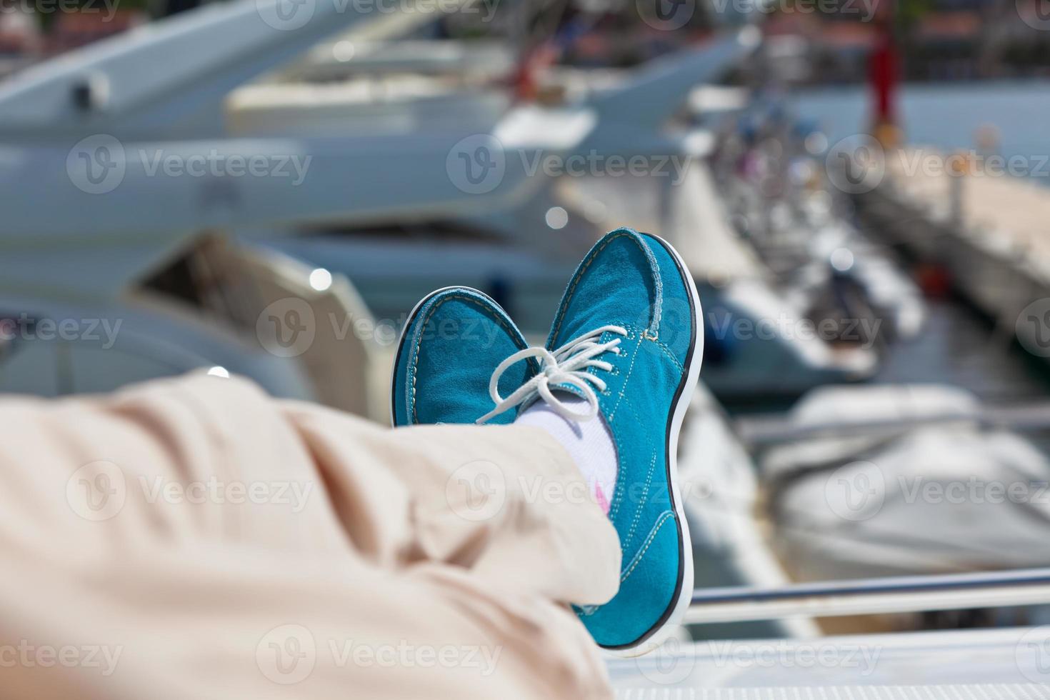 Human legs in pants and bright blue topsiders on yacht photo