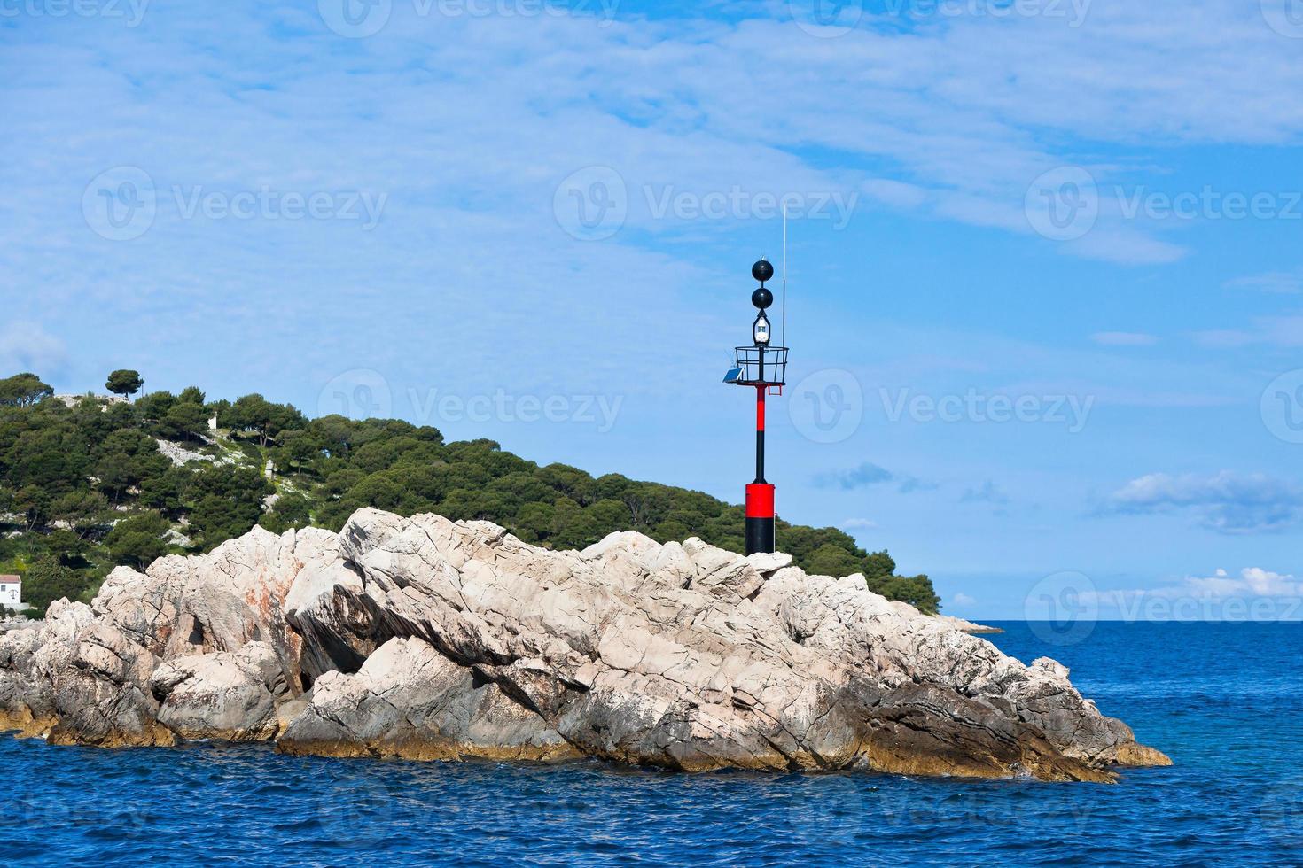 Nautical danger sign on a rock in the sea photo