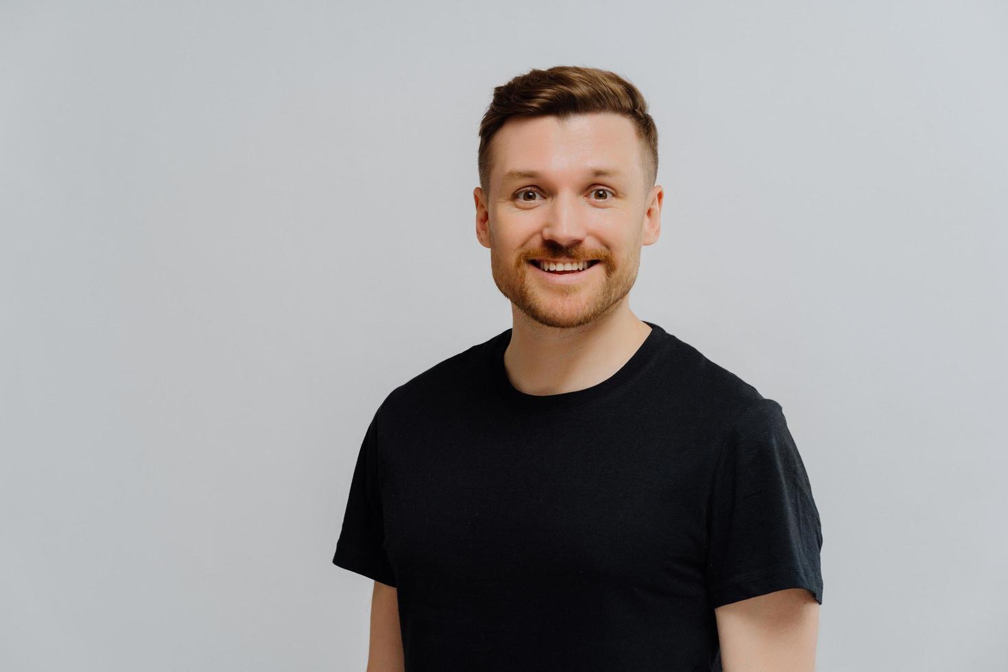 Good looking ginger man smiling at camera, expressing positivity photo