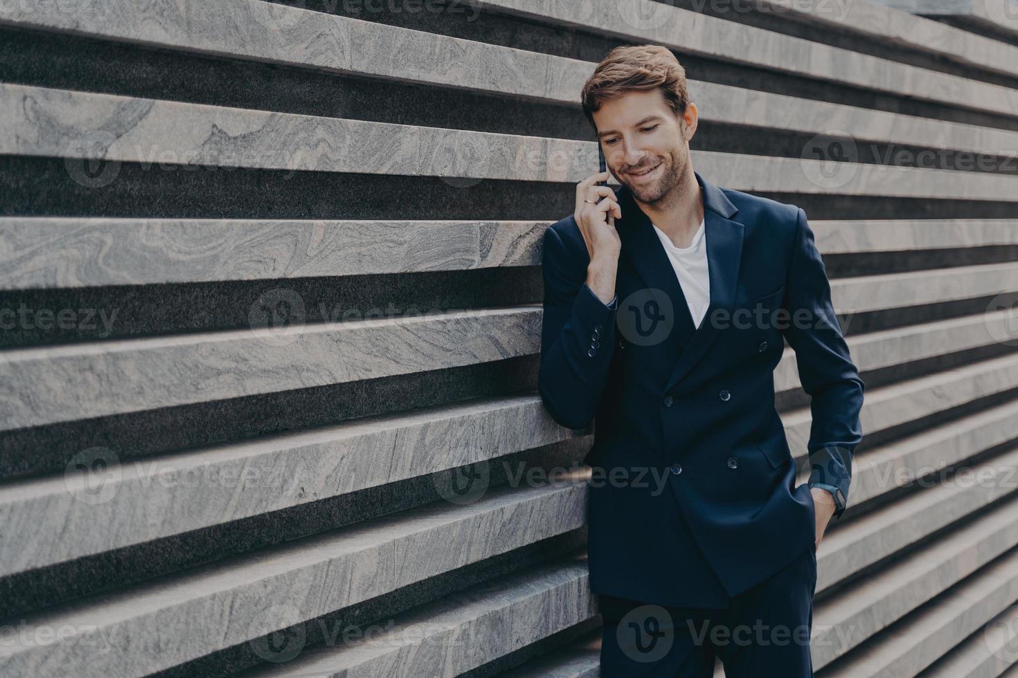 un hombre de negocios exitoso llama a través de un teléfono inteligente durante las conversaciones de descanso del trabajo con un socio comercial foto