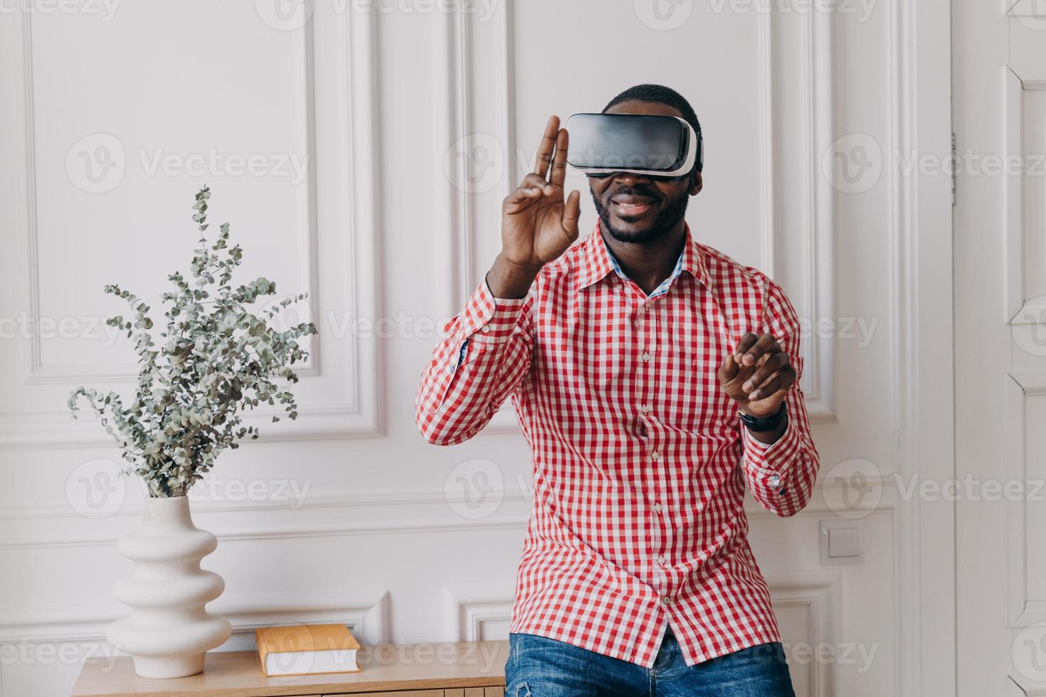Excited cheerful african man wearing VR glasses totaly immersed in augmented reality of 3d games photo