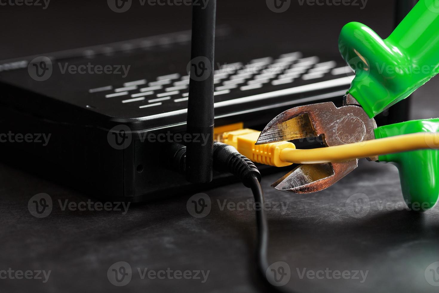 Cutting and disconnecting the network Internet connection with cutting Green pliers. photo