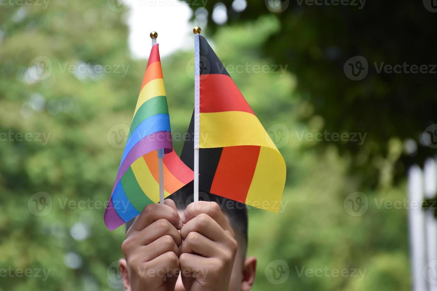 Rainbow flag and Germany national flag holding in hand, soft and selective focus, concept for celebration of lgbtq plus in pride month around the world. photo