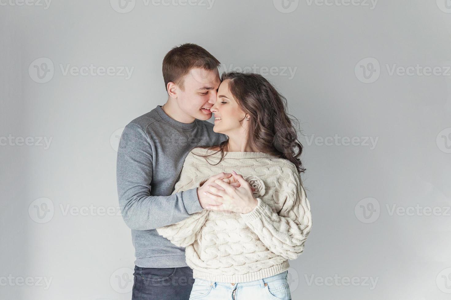 Romantic sexy couple in love having nice time together. Young woman hugging boyfriend, white background photo