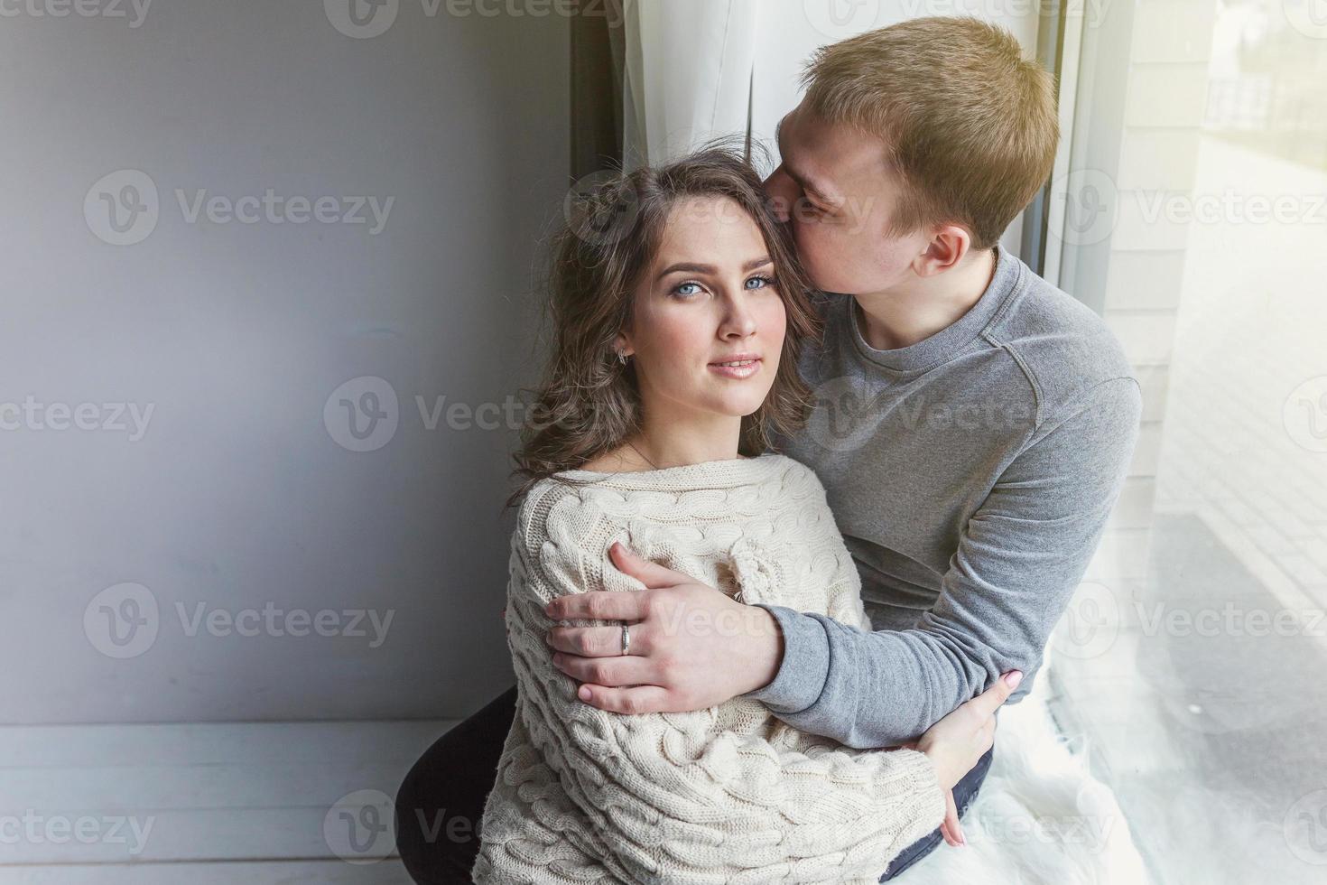 Romantic sexy couple in love having nice time together. Young woman hugging boyfriend, white background photo