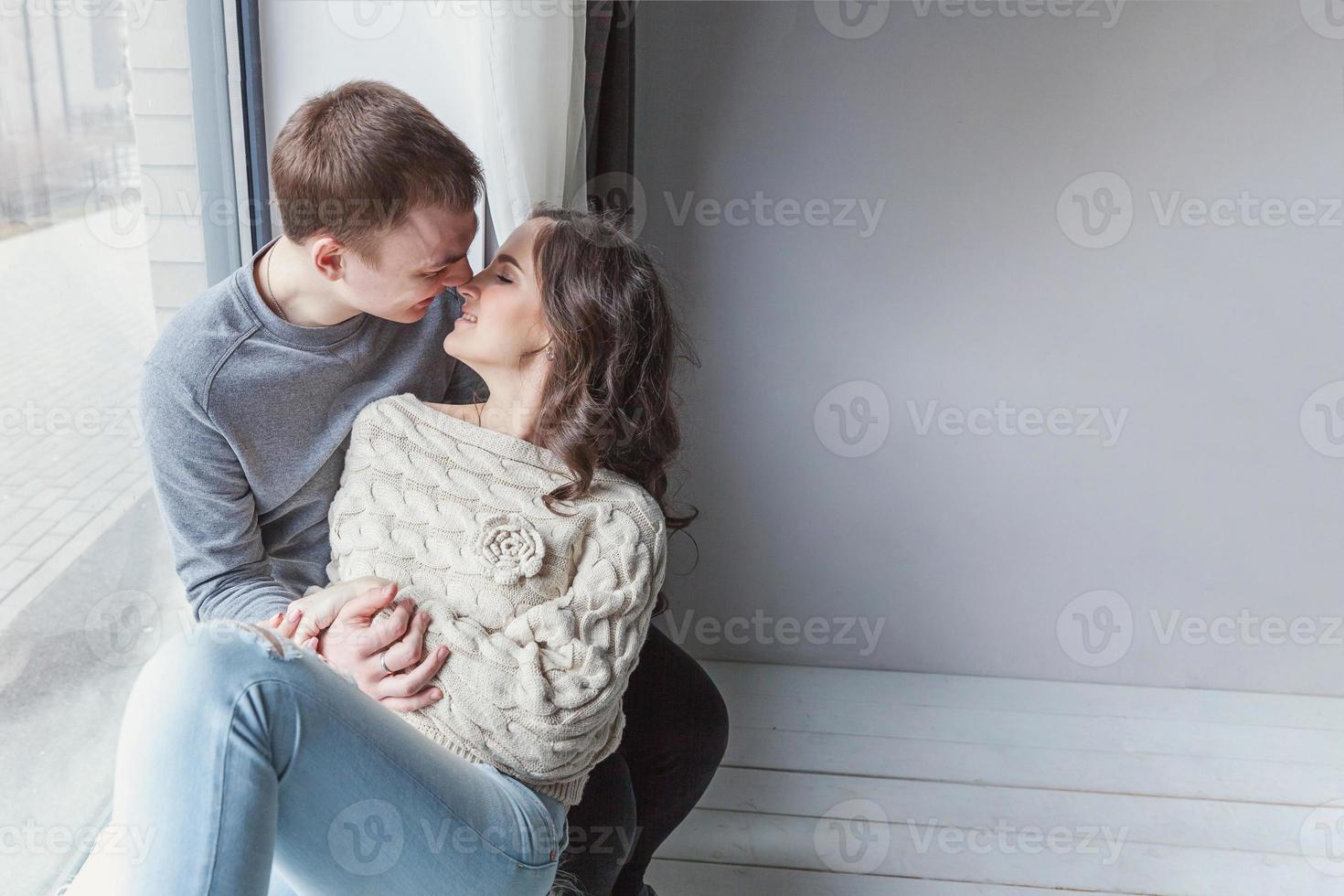 Romantic sexy couple in love having nice time together. Young woman hugging boyfriend, white background photo