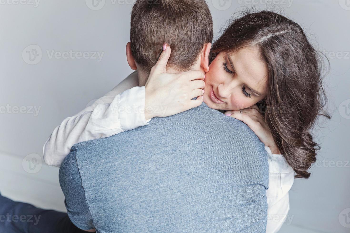 Romantic sexy couple in love having nice time together. Young woman hugging boyfriend, white background photo