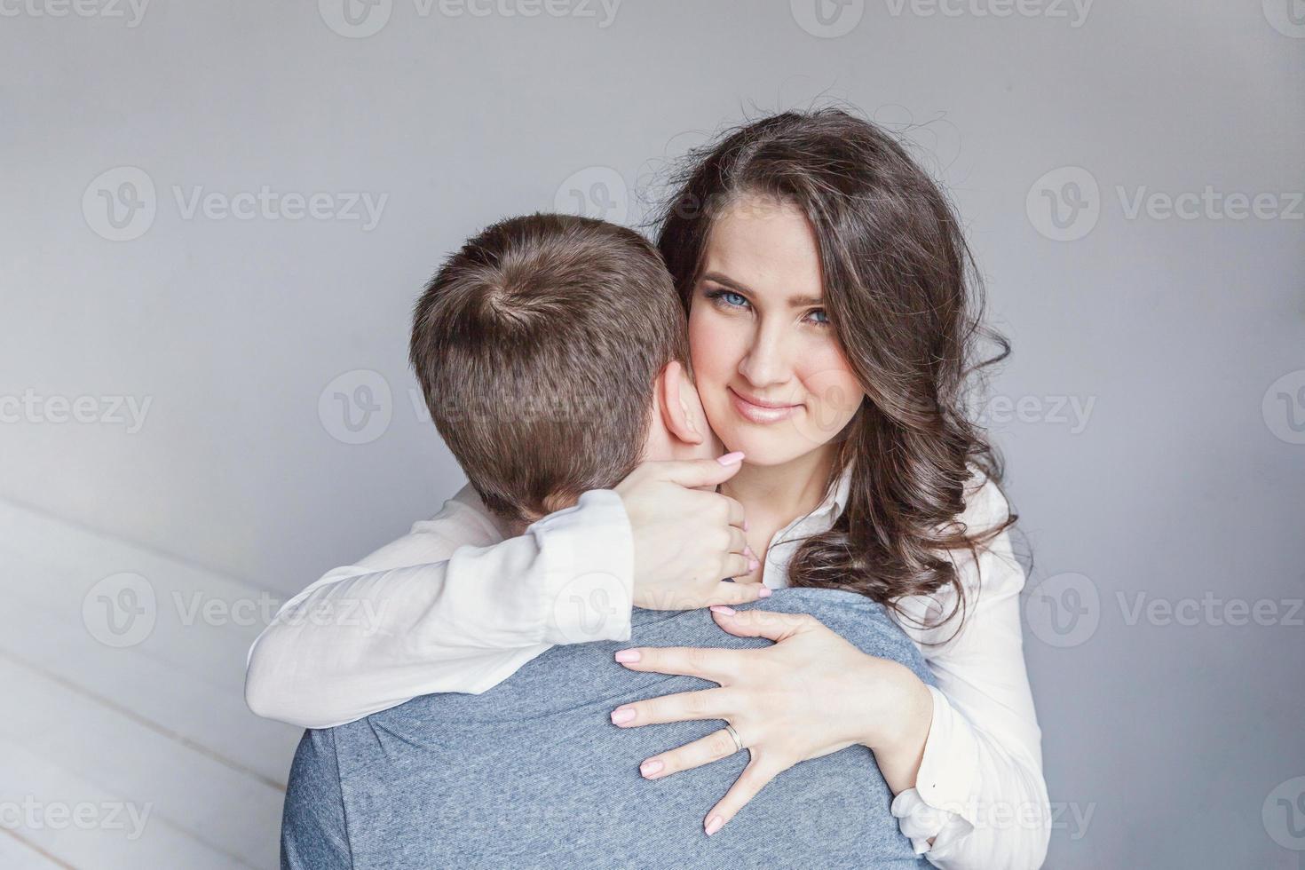 Romantic sexy couple in love having nice time together. Young woman hugging boyfriend, white background photo