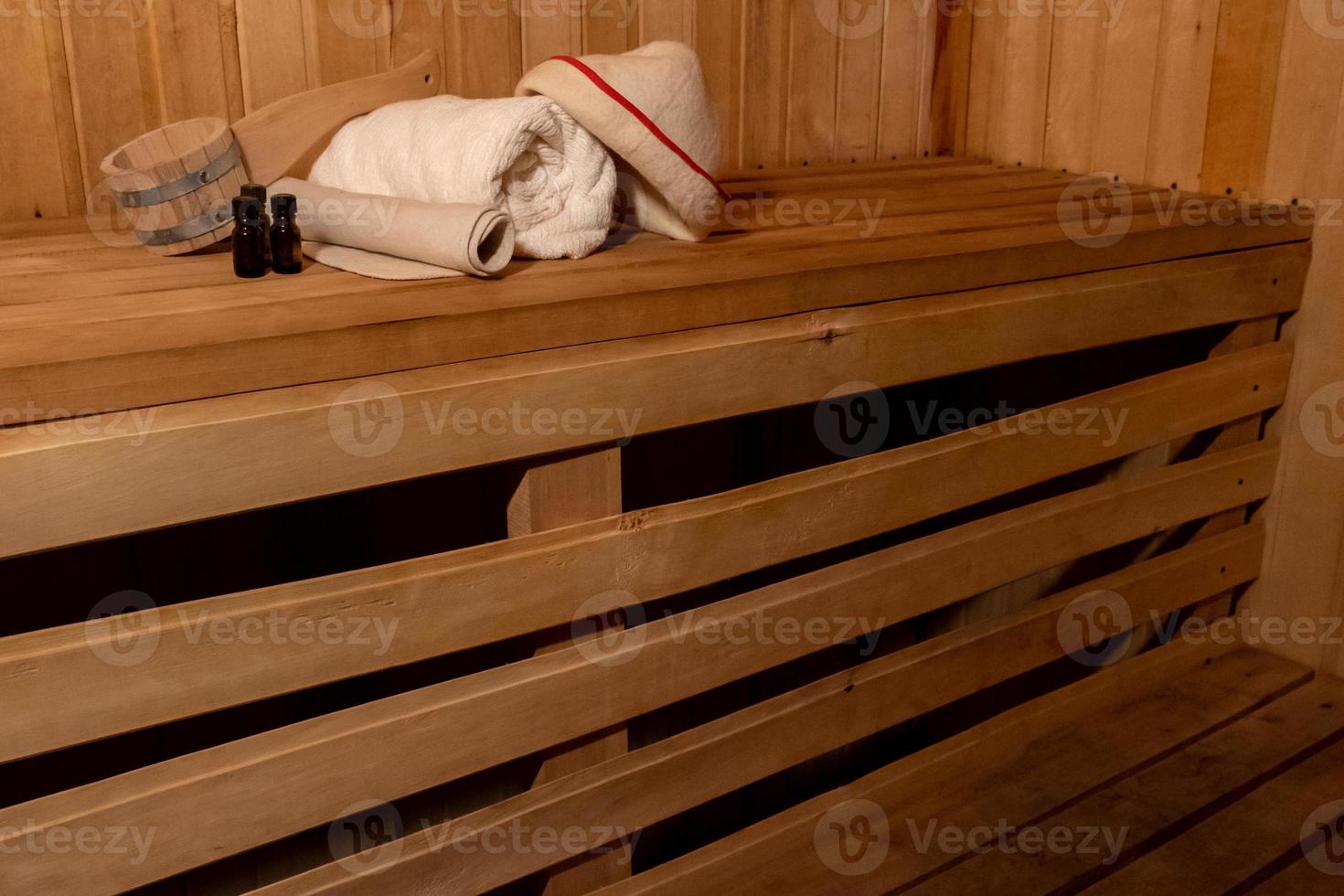 Traditional old Russian bathhouse SPA Concept. Interior details Finnish sauna steam room with traditional sauna accessories set basin towel aroma oil scoop felt. Relax country village bath concept. photo