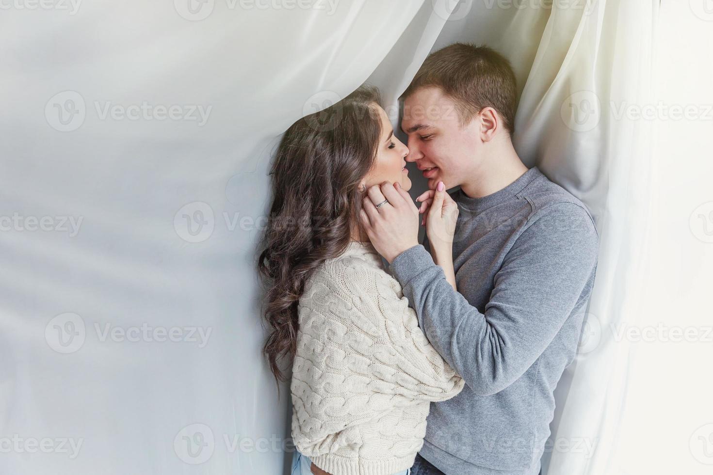 Romantic sexy couple in love having nice time together. Young woman hugging boyfriend, white background photo
