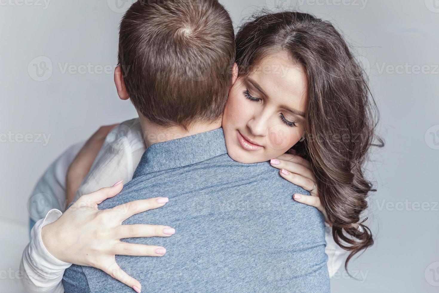 Romantic sexy couple in love having nice time together. Young woman hugging boyfriend, white background photo