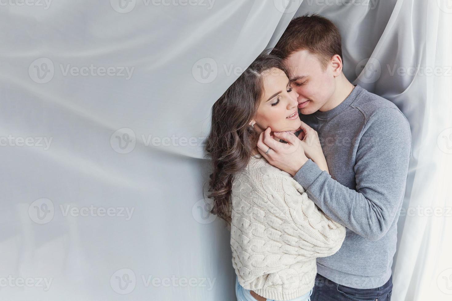 Romantic sexy couple in love having nice time together. Young woman hugging boyfriend, white background photo