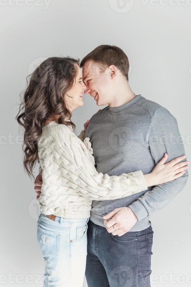 Romantic sexy couple in love having nice time together. Young woman hugging boyfriend, white background photo