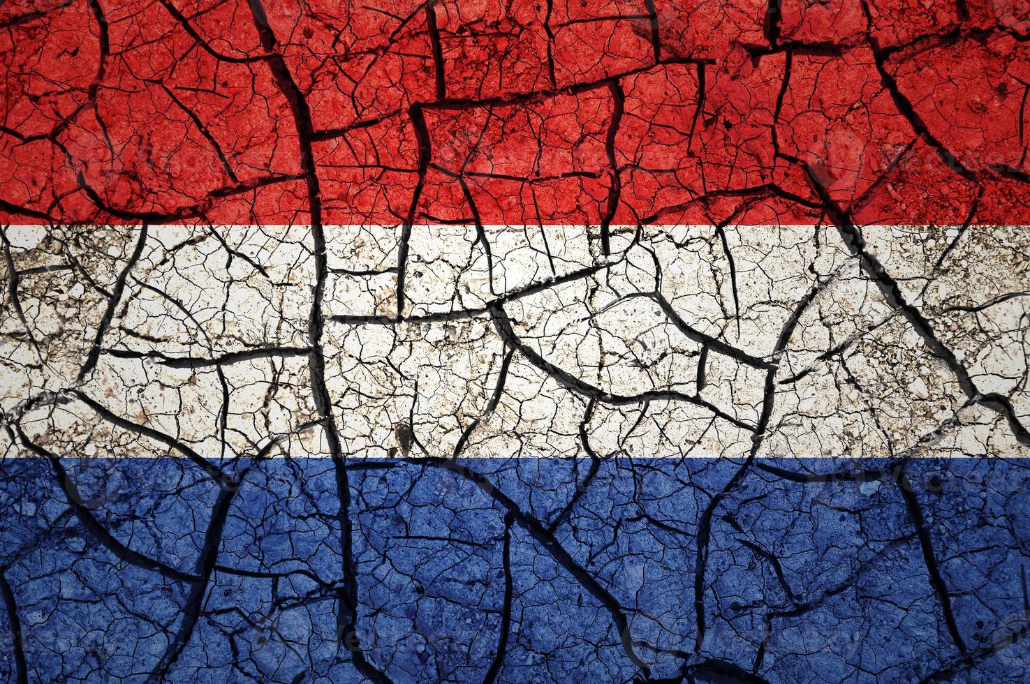 Dry soil pattern on the flag of Netherlands. Country with drought concept. Water problem. Dry cracked earth country. photo