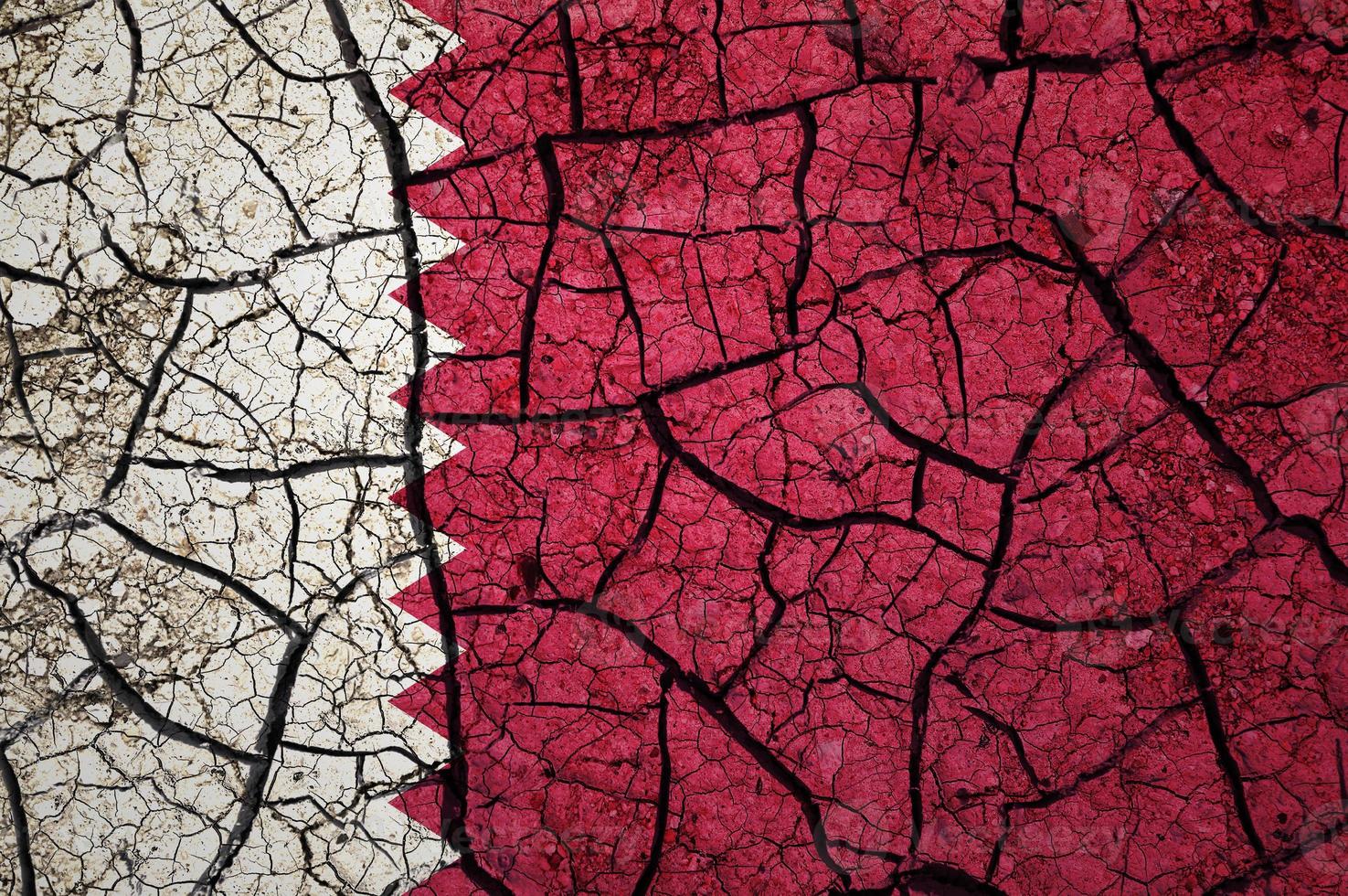 Dry soil pattern on the flag of Qatar. Country with drought concept. Water problem. Dry cracked earth country. photo