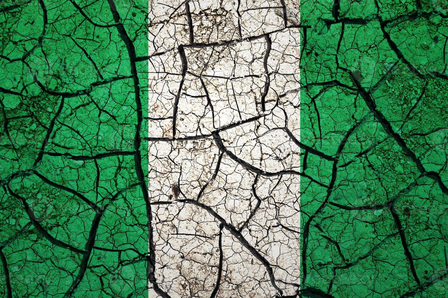 Dry soil pattern on the flag of Nigeria. Country with drought concept. Water problem. Dry cracked earth country. photo