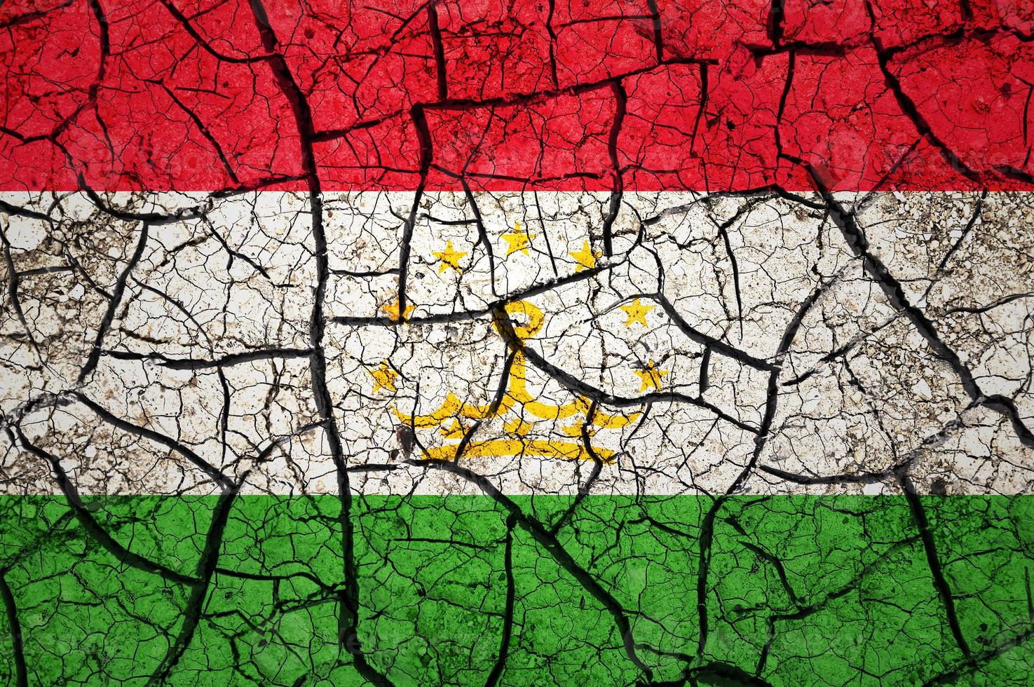 patrón de suelo seco en la bandera de tayikistán. país con concepto de sequía. problema del agua país de tierra seca y agrietada. foto