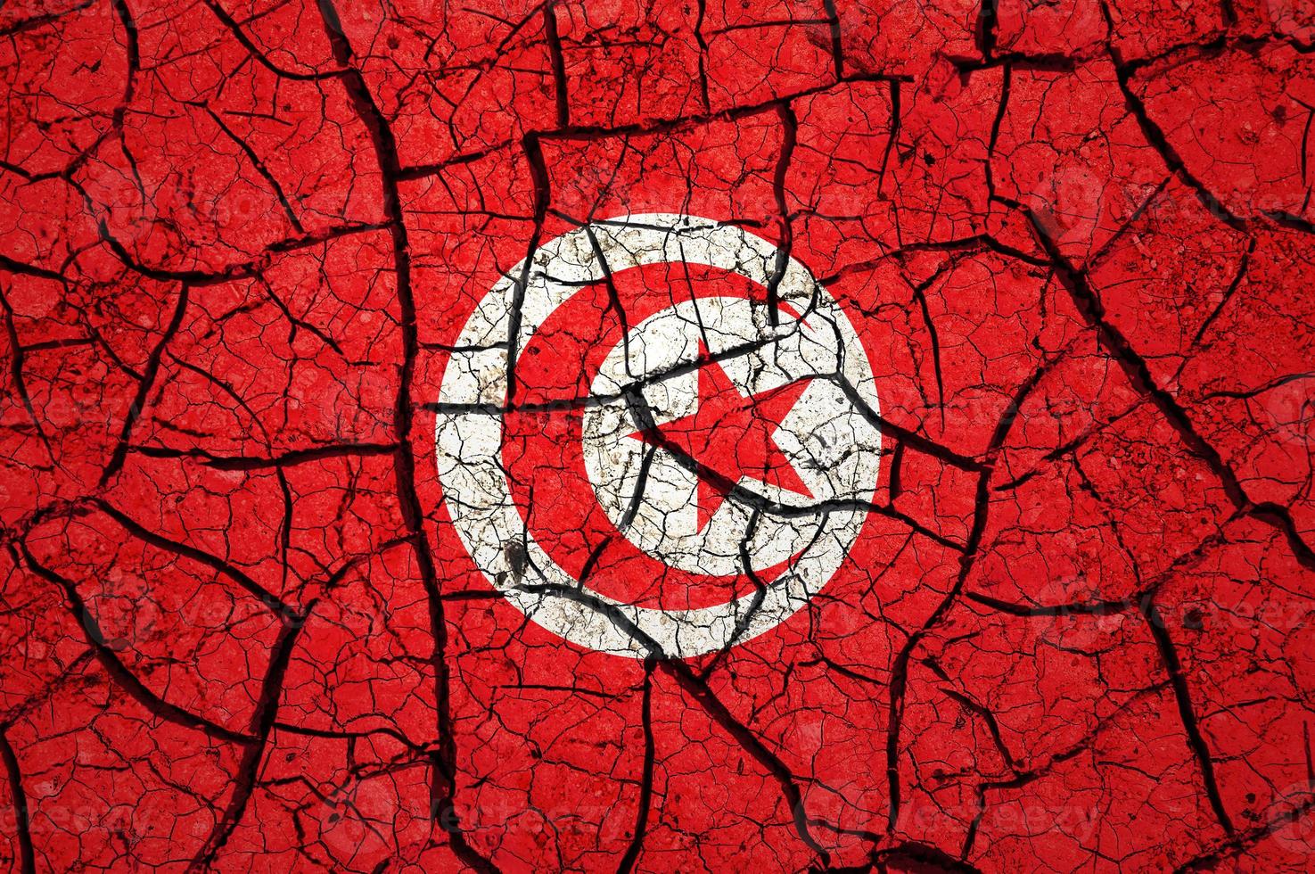 Dry soil pattern on the flag of Tunisia. Country with drought concept. Water problem. Dry cracked earth country. photo