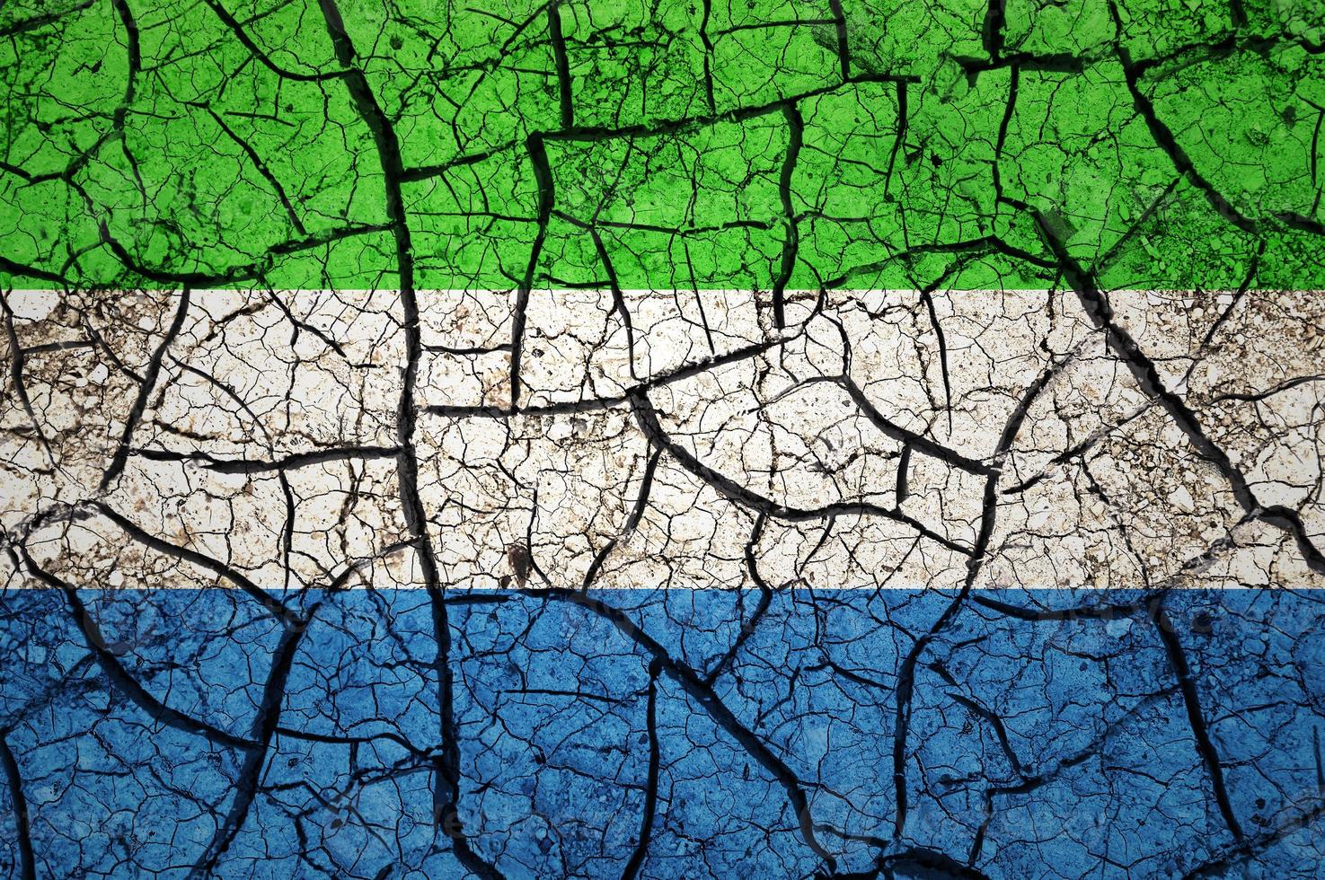 Dry soil pattern on the flag of Sierra Leone. Country with drought concept. Water problem. Dry cracked earth country. photo