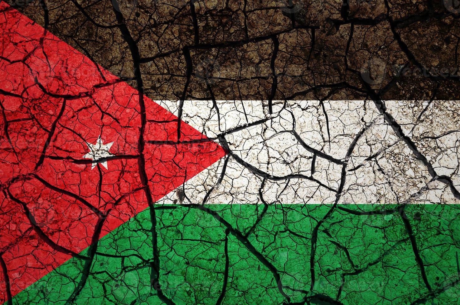 Dry soil pattern on the flag of Jordan. Country with drought concept. Water problem. Dry cracked earth country. photo