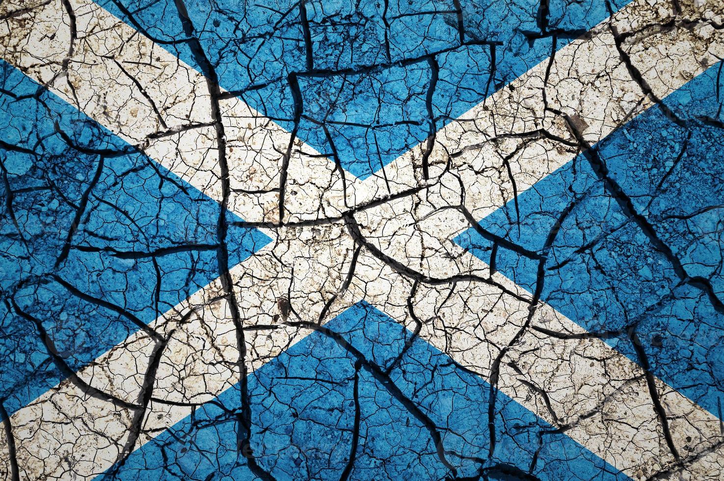 Dry soil pattern on the flag of Scotland. Country with drought concept. Water problem. Dry cracked earth country. photo