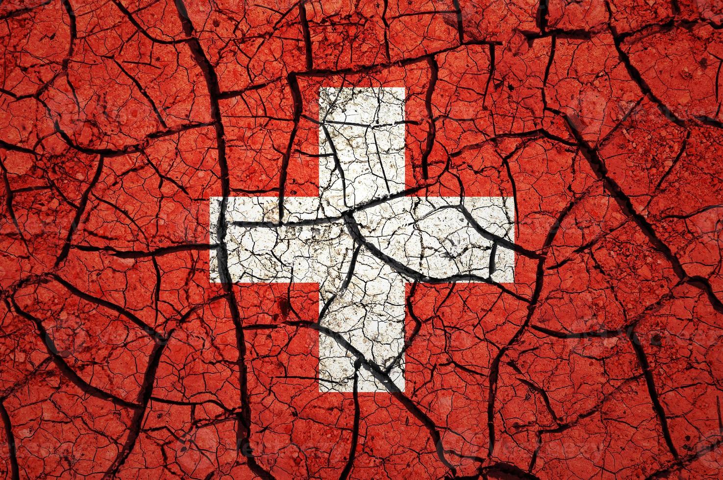 Dry soil pattern on the flag of Switzerland. Country with drought concept. Water problem. Dry cracked earth country. photo