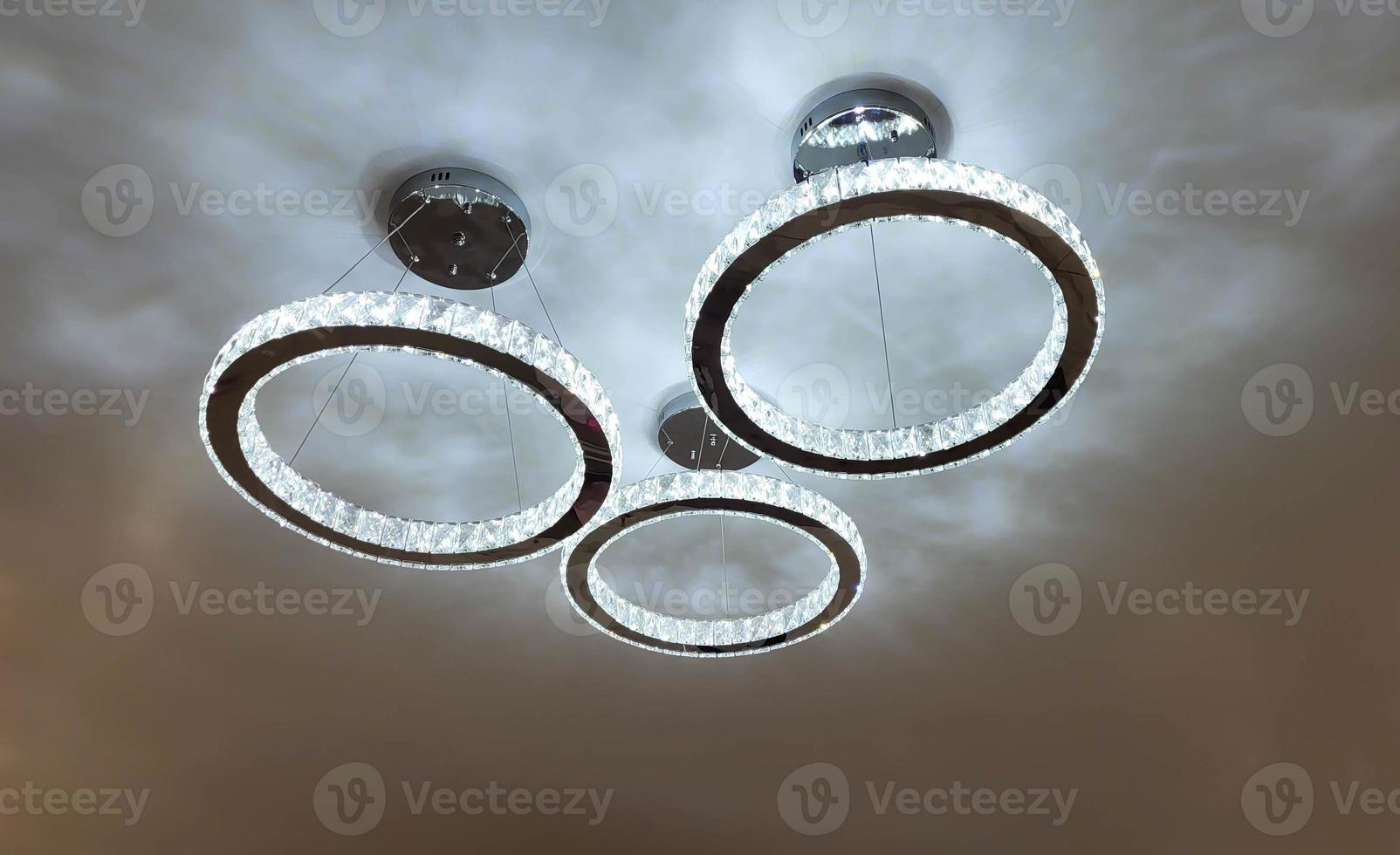 Beautiful glowing bright chandelier in the shape of circles on the ceiling photo