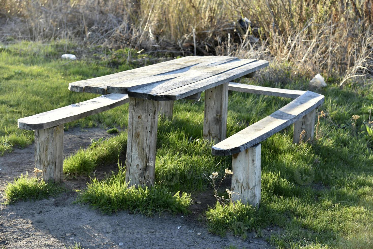 Benches and a table in a camping field in the spring evening. photo