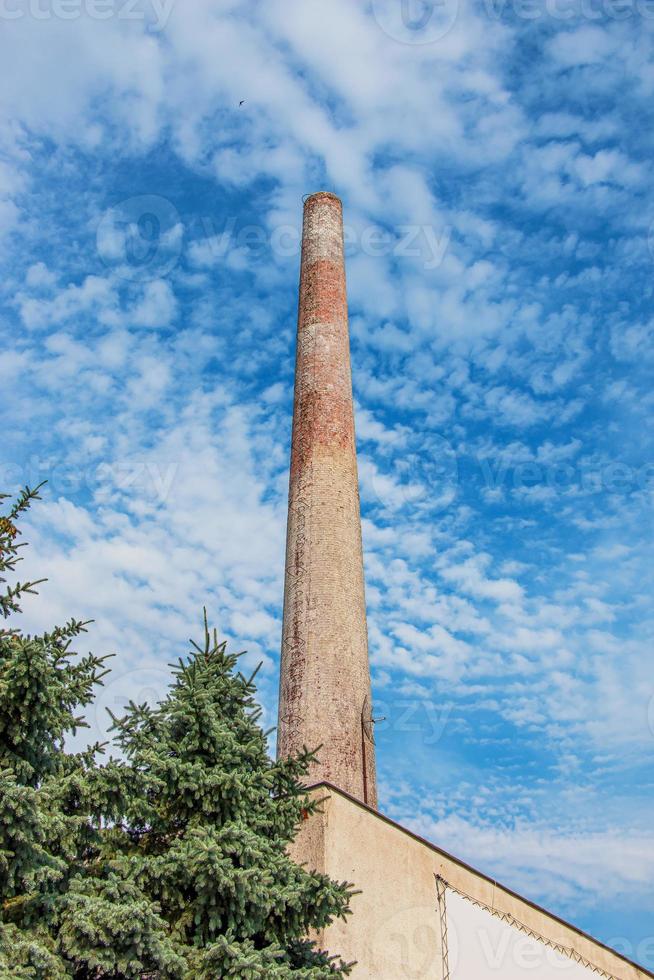 The pipe of a gas boiler house against the blue sky. No smoke comes out of the chimney. Energy crisis. photo