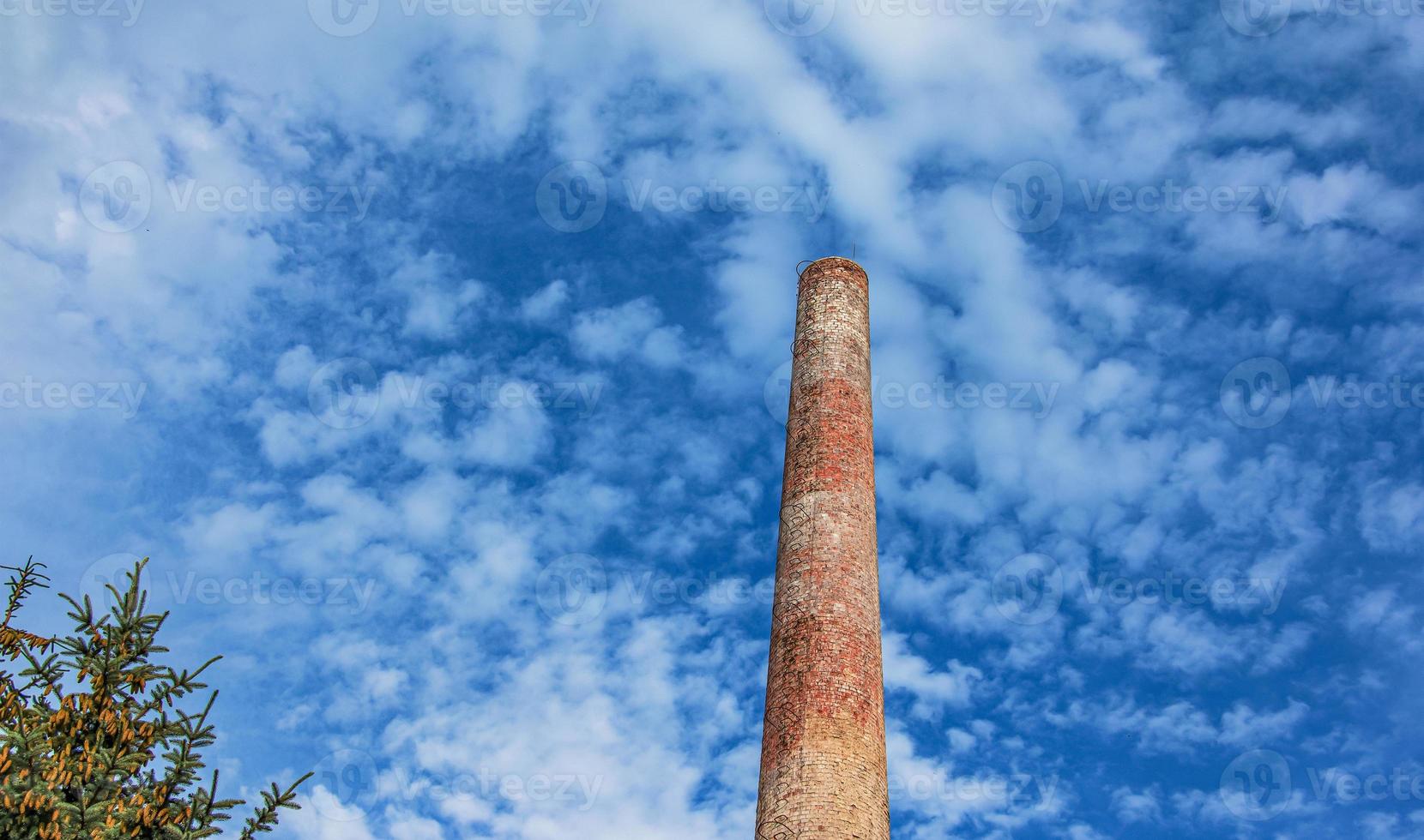 The pipe of a gas boiler house against the blue sky. No smoke comes out of the chimney. Energy crisis. photo